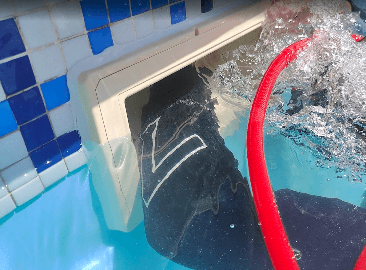 Técnico de Maquapool inspeccionando el skimmer de una piscina para localizar una fuga sin vaciar el agua